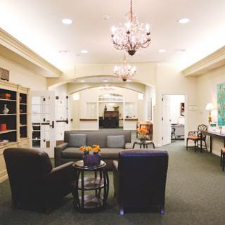 A modern living room with comfortable seating and a chandelier.