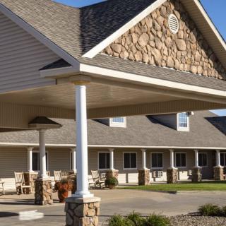 The exterior of a lodge or hotel featuring a large covered porch and stone details.