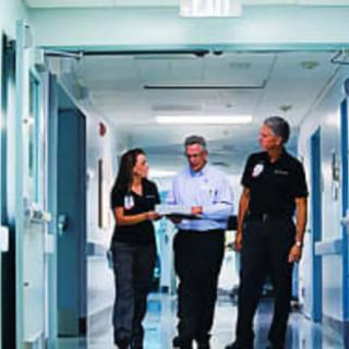 Healthcare professionals walking and discussing in a hospital hallway.