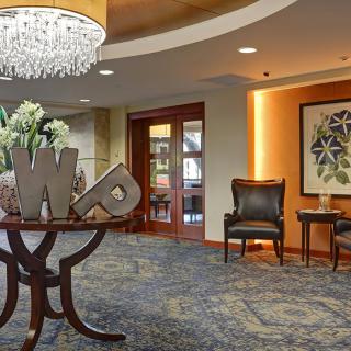 A well-decorated lobby with elegant furniture and a chandelier.