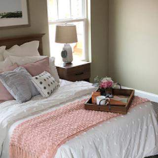 A beautifully arranged bedroom featuring soft bedding and a cozy atmosphere.