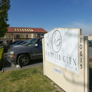A parking lot with a business sign for Charter Glen Apartments.