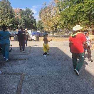 A group of people walking in a sunny outdoor space, enjoying the day.