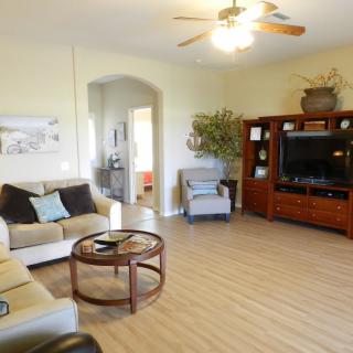 A cozy living room with comfortable seating and a large TV entertainment center.