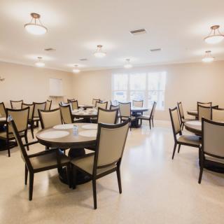 An empty dining room with neatly arranged tables and chairs.