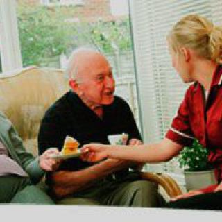 A caregiver assisting elderly individuals in a nursing home setting.