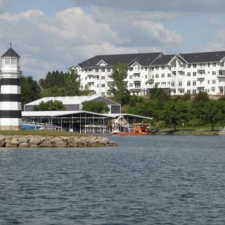 A scenic view featuring a lighthouse and hotel by the water.