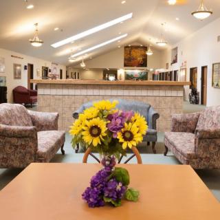 A cozy lobby with comfortable seating and a floral centerpiece on the table.
