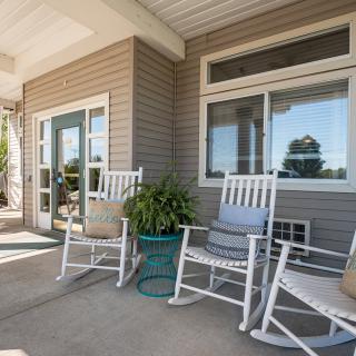 A cozy porch with rocking chairs and a potted plant.