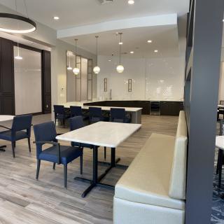 A modern dining area with neatly arranged tables and chairs, featuring stylish lighting.