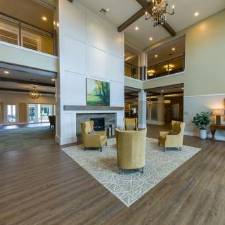 A spacious and modern lobby with comfortable seating and elegant chandeliers.