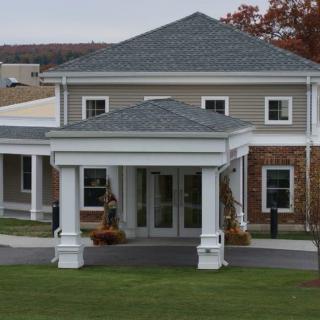 Front view of a residential building with a covered entrance and columns.