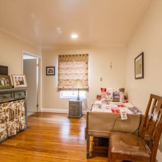 A cozy dining area with wooden floors, adorned with artwork and decorations.