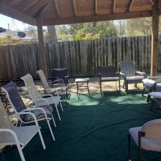 A cozy outdoor seating area with various chairs arranged for a gathering.