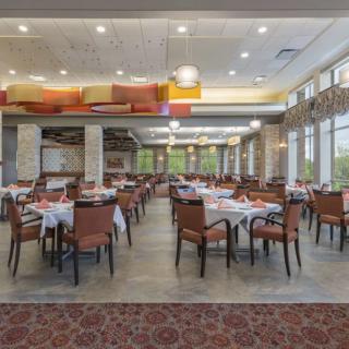 An elegant and empty restaurant dining area with neatly arranged tables and chairs.