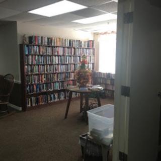 A cozy room filled with books on shelves and a table for reading.