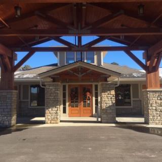A building entrance with prominent wood beams and stonework.