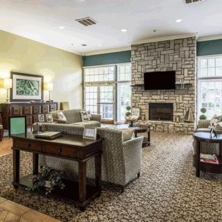A cozy living room with a stone fireplace and comfortable seating.