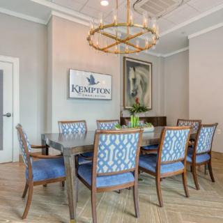 Elegant dining area with blue upholstered chairs and a modern chandelier.