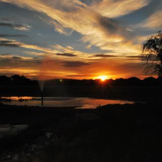 A serene sunset with vibrant colors reflecting over a calm water surface.