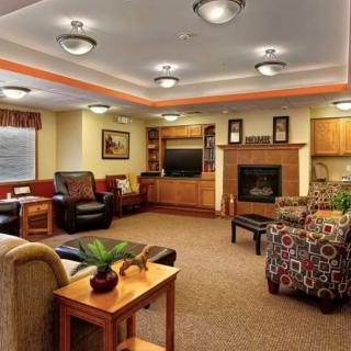A cozy living room with comfortable seating, a warm fireplace, and a television.