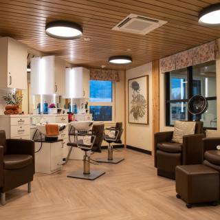 A modern hair salon interior with styling chairs, mirrors, and professional equipment.