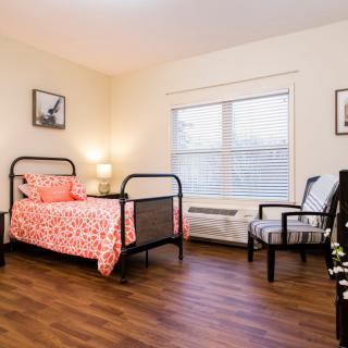 A cozy bedroom with a single bed, wooden floor, and stylish decor.