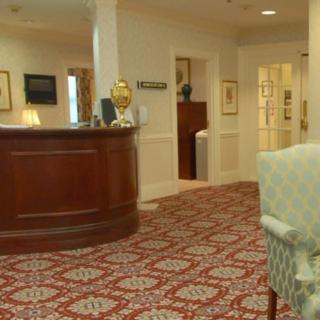 A cozy hotel lobby with a reception desk and classic decor.