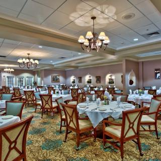 A well-appointed dining room with elegantly set tables and chandeliers.