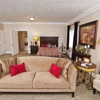 A cozy and well-decorated living room with a sofa, bed, and various furnishings.