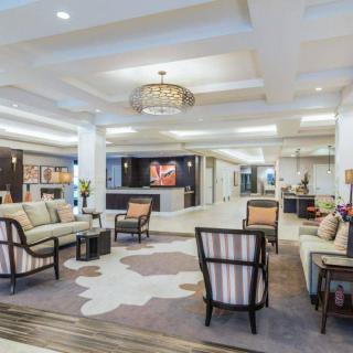 A spacious and elegantly designed hotel lobby featuring comfortable seating arrangements and a chandelier.