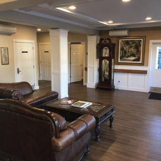 A cozy lobby area with leather sofas, a grandfather clock, and elegant decor.