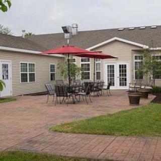A residential patio with outdoor seating and a red umbrella.