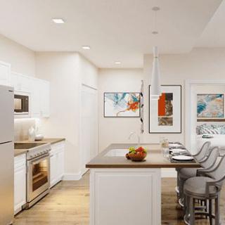 A modern kitchen featuring an island with bar stools, contemporary artwork, and sleek appliances.