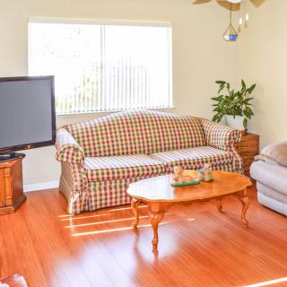 A cozy living room with a checkered sofa, television, and wooden coffee table.