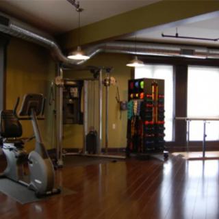 A well-equipped gym with exercise machines and weights in a modern indoor setting.