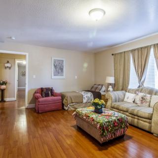 A cozy living room with a sofa, armchair, and a decorated coffee table.