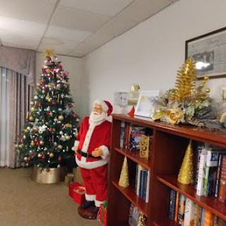 A festive corner featuring a Christmas tree and a Santa Claus figure, creating a cozy holiday atmosphere.