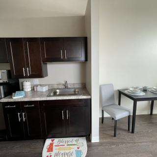 Modern kitchen with dark cabinets and a small dining area.