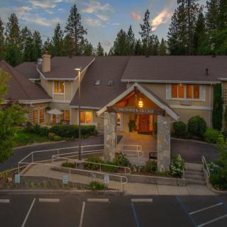 A large, inviting house surrounded by trees at dusk.