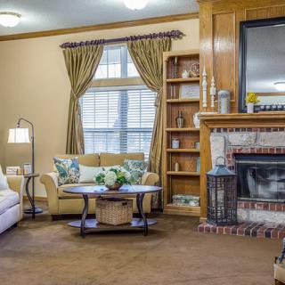 A cozy living room featuring a fireplace, bookshelf, and comfortable seating.