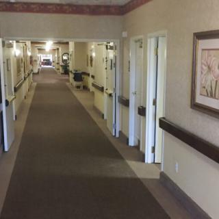 A long corridor with doors lining both sides in a building interior.