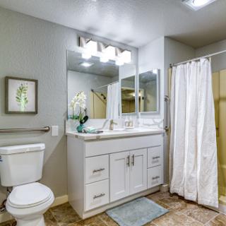 A modern bathroom featuring white cabinetry, a clean design, and functional elements.