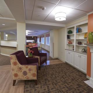A cozy lounge interior with comfortable seating and decorative shelves.