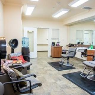 A modern hair salon interior featuring styling stations and a comfortable waiting area.