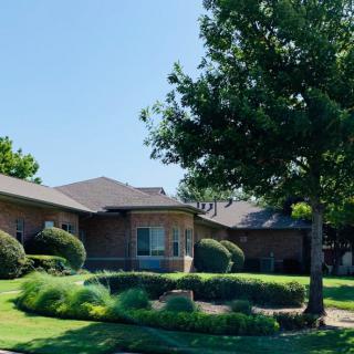 A suburban house with a well-maintained garden and lush green lawn.