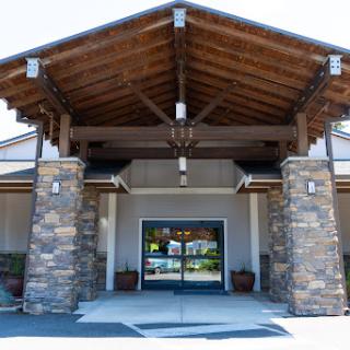 The inviting entrance of a beautifully designed building featuring wood and stone architecture.