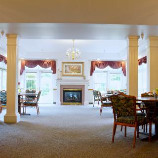 A spacious dining room with a fireplace and elegant furnishings.