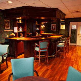 A cozy and inviting bar area featuring wooden furniture and warm lighting.