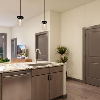 A modern kitchen interior featuring a central island with pendant lights and a sleek countertop.